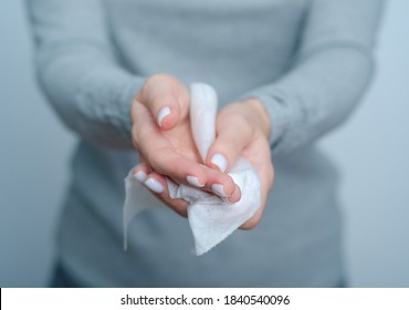 Woman cleans hands wet antibacterial wipe on gray background - Shutterstock ID 1840540096