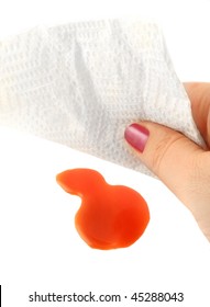 Woman Cleans Up A Tomato Juice Spill With A Paper Towel On A White Background