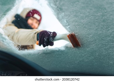 Woman Cleans Windshield With Ice Scraper