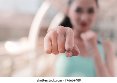 Woman clenched fist ready to punch close up with copy space. workout for martial art boxing, self defense. 