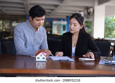 Woman Client Signs A Rental Application Form For A New House. Real Estate Agent Meets With Her Potential Client.