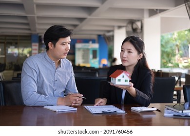 Woman Client Signs A Rental Application Form For A New House. Real Estate Agent Meets With Her Potential Client.