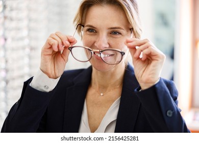 Woman client takes off the glasses that did not fit her in ophthalmic store - Powered by Shutterstock