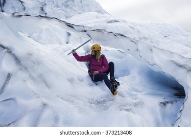 Woman Climber Sitting With An Ice Pick In His Hand On A Glacier In Iceland