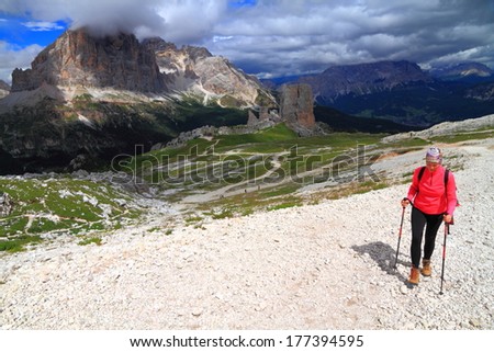Woman climber walks the wide trail to Averau refuge, Dolomite Alps, Italy