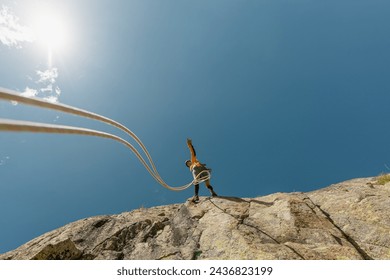 woman climbing in the mountain at sunset with lus rays, security, confidence business woman, rope access, life insurance. - Powered by Shutterstock