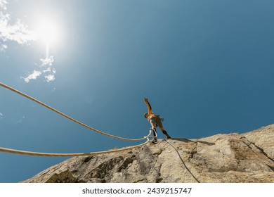 woman climbing in the mountain at sunset with lus rays, security, confidence business woman, rope access, life insurance. - Powered by Shutterstock