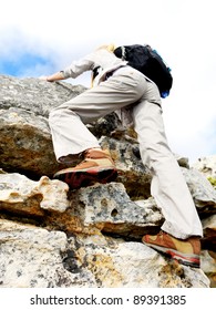 Woman Climbing Rock Face, View From Bottom With Selective Focus On Hiking Boot