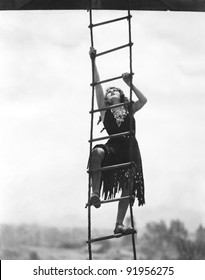 Woman Climbing Up A Rope Ladder