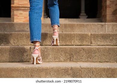 Woman Climbing Stairs In High Heels. You Can See Her Feet Going Up The Steps.