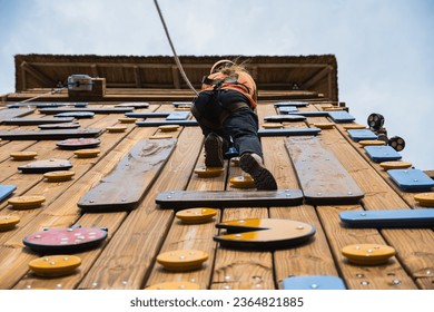 Woman climbing wooden wall with rocks (Palestra) - Shutterstock ID 2364821885