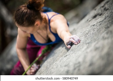 woman climbs a rock - Shutterstock ID 580940749