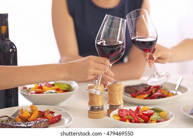 Woman clinking glasses with wine at lunch time
