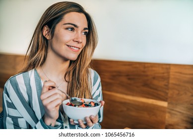 woman close up eating oat and fruits bowl for breakfast