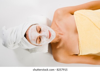 Woman With Closed Eyes And Facemask And Towels On White.