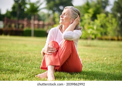 Woman with closed eyes sunbathing on lawn