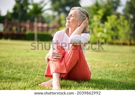 Woman with closed eyes sunbathing on lawn
