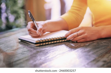 Woman, closeup and notebook for notes, schedule and planning on table in cafe with pen. Wife, writing and notepad with diary, marriage journal and letter for self care, growth and relationship goals - Powered by Shutterstock