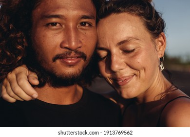 A Woman Closing Her Eyes And Smiling Blissfully Hugs The Neck Of An East Asian Man. High Quality Photo