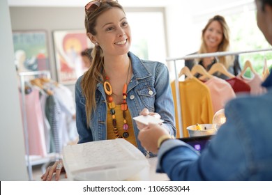 Woman in clothing store paying with credit card