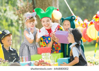 Woman As A Clown Giving Presents For Kids On A Party