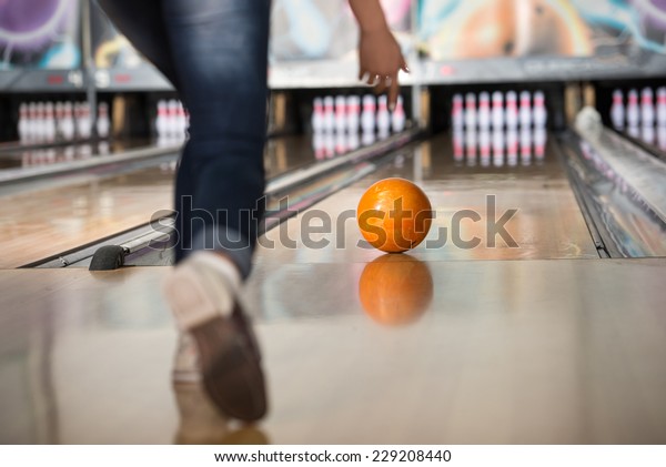Woman in club for\
bowling is throwing ball.