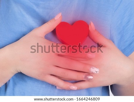 Woman is clutching her chest, acute pain possible heart attack, red