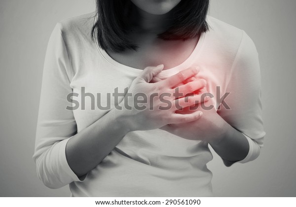 Woman is clutching her chest, acute pain possible\
heart attack