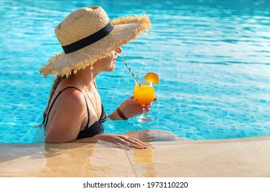 Woman With Cocktail In The Pool. Selective Focus. Drink.