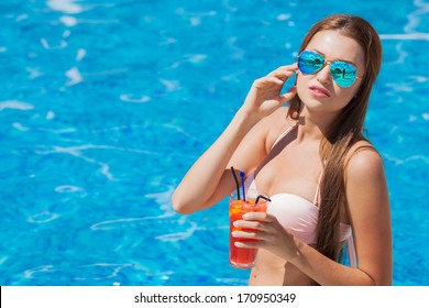 woman with cocktail in a swimming pool - Powered by Shutterstock