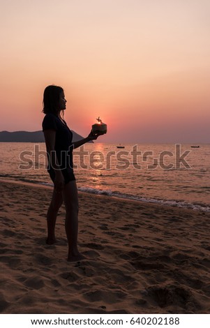 woman  with coconut drink on the beach,Sunset on the beach by the ocean with collorful sky, Pattaya Thailand