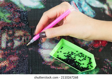 Woman collect diamond painting or diamond mosaic close-up