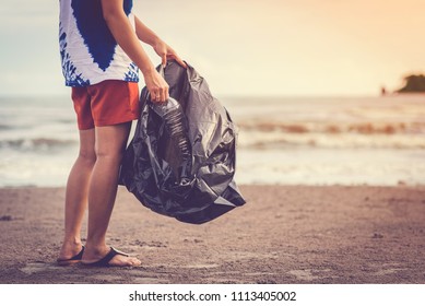 Woman are collecting garbage on the beach with the backdrop of the light of the sun. / love the sea concept. - Powered by Shutterstock