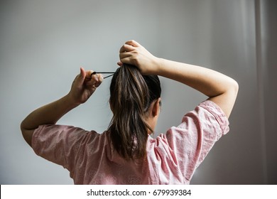 Woman collecting hair in a ponytail