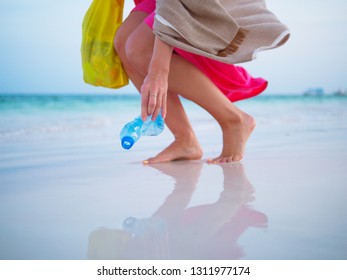 Woman Collecting Plastic Trash On The Beach.