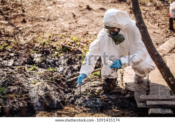 Woman collects soil in a test tube. soil\
analysis, environment, ecology\
concept.