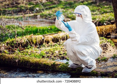 Woman Collects Water In A Test Tube. Ecology And Environmental Pollution Concept.