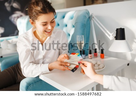 Woman with color palette choosing nail varnish