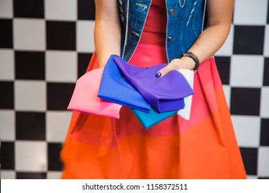 Woman with colorful fabric samples, female stylist shopper holding pieces of textile on background