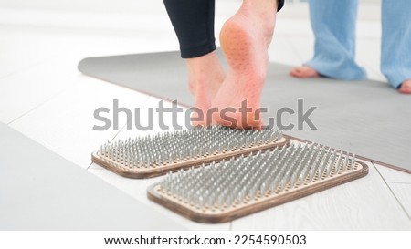 A woman comes down from the sadhu boards. Close-up of feet with prints after nails. 