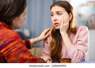 Woman comforting her female friend who sitting at table and feeling depressed. - Shutterstock ID 2186529095