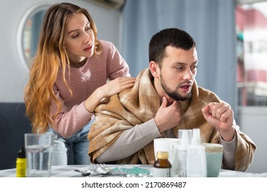 Woman comforting her ill husband who sitting at table with medicines at home. - Shutterstock ID 2170869487