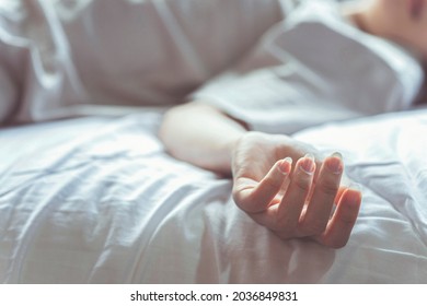 Woman Committing Suicide In Bed, Focus On The Hand Of Dead Body. The Concept Of Die Alone.