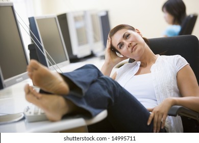 Woman In Computer Room With Feet Up Thinking