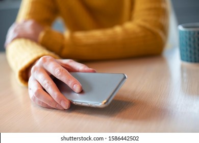 Woman Concerned About Excessive Use Of Social Media Laying Mobile Phone Down On Table - Shutterstock ID 1586442502
