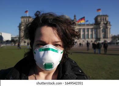Frau besorgt wegen des Corona-Virus mit einer medizinischen Maske vor dem Reichstagsgebäude, Berlin Deutschland