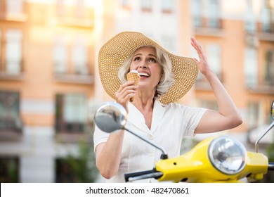 Woman With Cone Ice Cream. Mature Lady Is Looking Up. Soon It's Going To Rain. Must Continue My Travel.