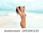 Woman, confidence and bikini in water or tropical island for holiday, summer vacation and relax with blue sky. Person, swimsuit or tourist at seaside for sun tan, clean air and fun in Maldives beach