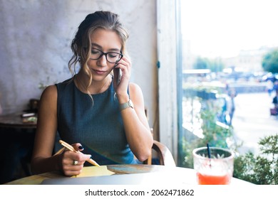 Woman Confident Government Worker Talking Via Mobile Phone And Writing Notary While Sitting In Restaurant During Break At Job. 