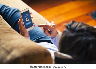 Woman configuring privacy settings on the mobile phone, lying down at home. Blue screen. "Privacy settings appears on the screen.